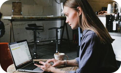 New Zealand employee typing on their laptop within the office